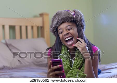 Stock Image - Teenage girl listening to headphones. Fotosearch