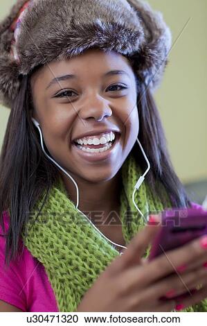 Stock Image - Teenage girl listening to headphones. Fotosearch