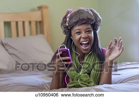 Stock Photograph - Teenage girl listening to headphones. Fotosearch