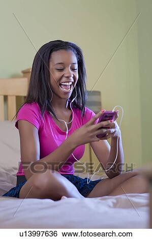 Teenage girl listening to headphones View Large Photo Image Stock Photograph - Teenage girl listening to headphones. Fotosearch