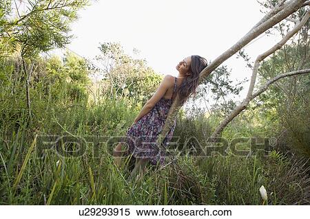 Teenage girl resting on curved tree View Large Photo Image Stock Photography - Teenage girl resting on curved tree. Fotosearch