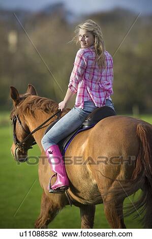 Teenage girl riding horse in field View Large Photo Image Stock Image - Teenage girl riding horse in field. Fotosearch