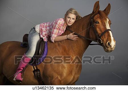 Stock Photography - Teenage girl riding horse outdoors. Fotosearch