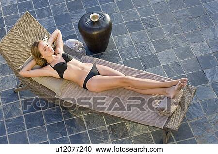 Stock Image - Teenage girl sleeping in lawn chair. Fotosearch