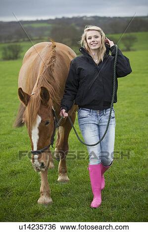 Teenage girl walking horse in field View Large Photo Image Stock Photograph - Teenage girl walking horse in field. Fotosearch