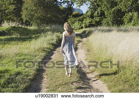 Teenage girl walking on dirt path View Large Photo Image Stock Image - Teenage girl walking on dirt path. Fotosearch