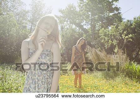Picture - Teenage girls in field of flowers. Fotosearch