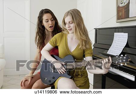 Stock Photograph - Teenage girls playing music together. Fotosearch