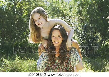 Stock Image - Teenage girls playing outdoors. Fotosearch