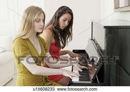 Teenage girls playing piano together View Large Photo Image Stock Image - Teenage girls playing piano together. Fotosearch