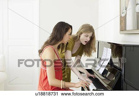 Teenage girls playing piano together View Large Photo Image Stock Image - Teenage girls playing piano together. Fotosearch