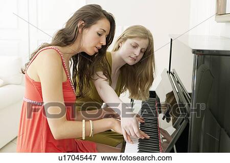 Stock Photo - Teenage girls playing piano together. Fotosearch