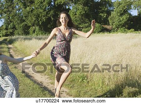 Picture - Teenage girls skipping on dirt path. Fotosearch