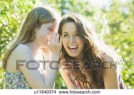 Teenage girls whispering outdoors View Large Photo Image Picture - Teenage girls whispering outdoors. Fotosearch