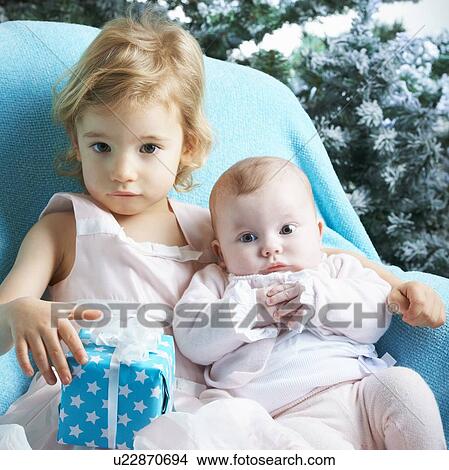 Picture - Toddler and infant sibling with gift. Fotosearch