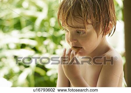 Stock Image - Toddler boy eating cookie outdoors. Fotosearch