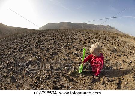 Toddler playing with shovel in desert View Large Photo Image Picture - Toddler playing with shovel in desert. Fotosearch