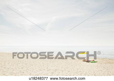 Stock Photo - Umbrella and towels on beach. Fotosearch