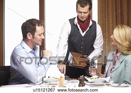 Waiter serving business people in cafe View Large Photo Image Stock Photo - Waiter serving business people in cafe. Fotosearch