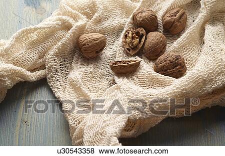 Walnuts in knitted fabric on table View Large Photo Image Stock Photo - Walnuts in knitted fabric on table. Fotosearch