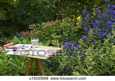 Stock Photo - Watercolors and pad on easel outdoors. Fotosearch