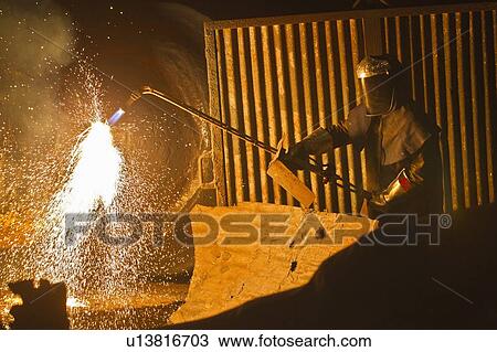 Stock Image - Welder at work in steel forge. Fotosearch