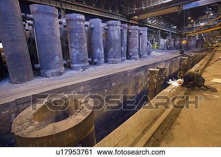 Stock Image - Welder at work in steel forge. Fotosearch