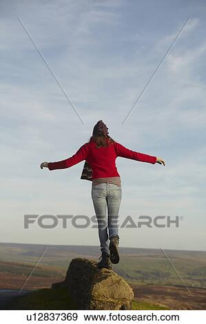 Woman balancing on rock wall View Large Photo Image Stock Photo - Woman balancing on rock wall. Fotosearch
