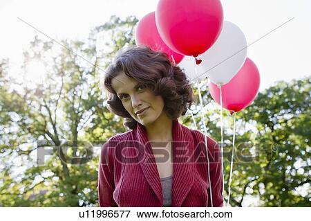 Woman carrying balloons outdoors View Large Photo Image Stock Photo - Woman carrying balloons outdoors. Fotosearch
