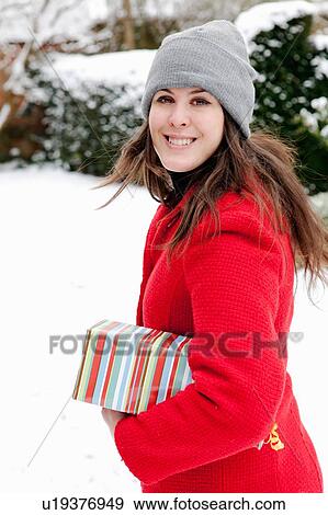Woman carrying wrapped gift in snow View Large Photo Image Stock Photo - Woman carrying wrapped gift in snow. Fotosearch