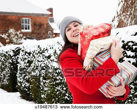 Woman carrying wrapped gifts in snow View Large Photo Image Stock Image - Woman carrying wrapped gifts in snow. Fotosearch