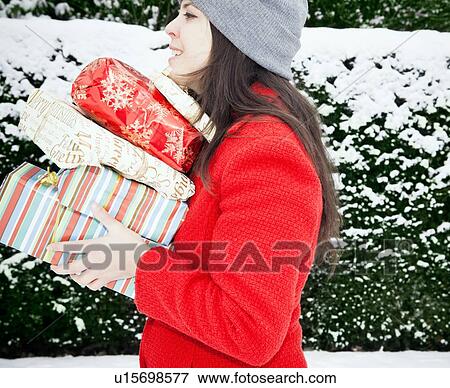 Woman carrying wrapped gifts in snow View Large Photo Image Stock Photo - Woman carrying wrapped gifts in snow. Fotosearch