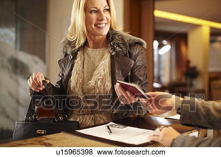 Woman checking in to hotel View Large Photo Image Stock Photo - Woman checking in to hotel. Fotosearch