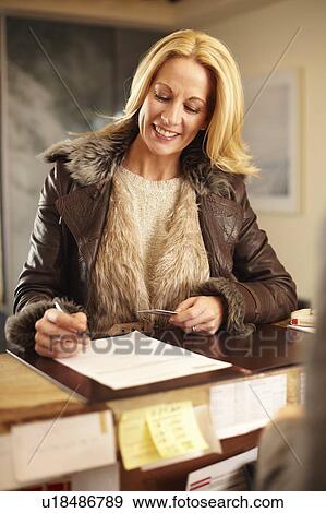 Stock Photo - Woman checking in to hotel. Fotosearch
