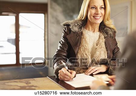 Woman checking in to hotel View Large Photo Image Stock Photograph - Woman checking in to hotel. Fotosearch
