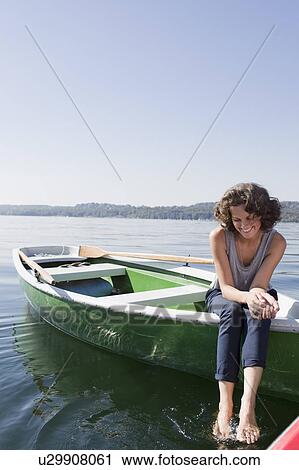 Woman dangling feet from boat in lake View Large Photo Image Stock Image - Woman dangling feet from boat in lake. Fotosearch