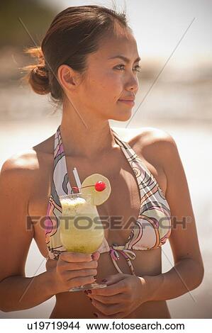 Woman drinking cocktail on beach View Large Photo Image Picture - Woman drinking cocktail on beach. Fotosearch