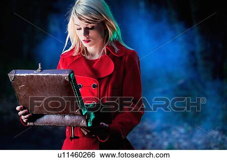 Stock Photograph - Woman examining contents of suitcase. Fotosearch