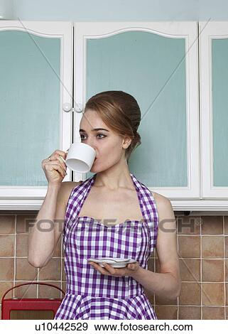 Woman having cup of coffee in kitchen View Large Photo Image Stock Photo - Woman having cup of coffee in kitchen. Fotosearch