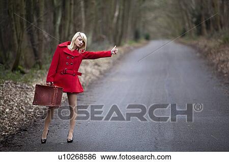 Stock Photograph - Woman hitch hiking in woods. Fotosearch