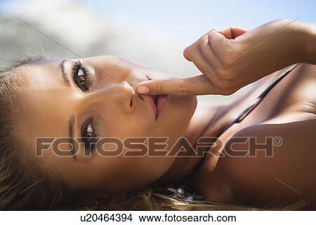 Woman holding finger to her lips View Large Photo Image Picture - Woman holding finger to her lips. Fotosearch