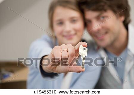Woman holding key to new home View Large Photo Image Stock Image - Woman holding key to new home. Fotosearch