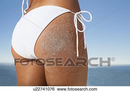 Stock Photograph - Woman in bikini covered in sand. Fotosearch