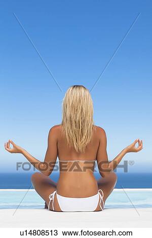 Woman in bikini meditating by pool View Large Photo Image Stock Image - Woman in bikini meditating by pool. Fotosearch