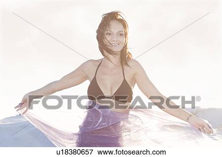 Stock Photo - Woman in bikini playing with sarong. Fotosearch