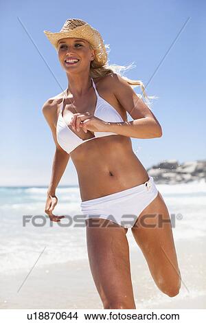Picture - Woman in bikini running on beach. Fotosearch