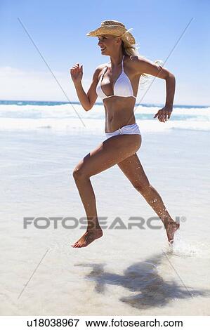 Stock Photo - Woman in bikini running on beach. Fotosearch