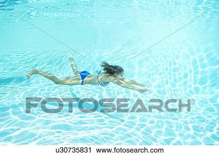 Woman in bikini swimming in pool View Large Photo Image Stock Image - Woman in bikini swimming in pool. Fotosearch