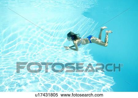 Stock Photography - Woman in bikini swimming in pool. Fotosearch