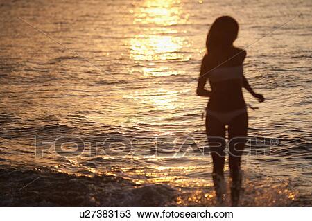 Woman in bikini walking in waves View Large Photo Image Stock Image - Woman in bikini walking in waves. Fotosearch